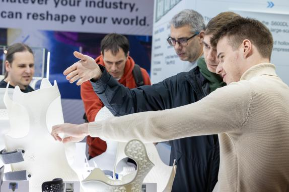 Visitantes observando peças impressas em 3D com tecnologia SLS no estande da TPM3D na Formenxt Frankfurt 2024