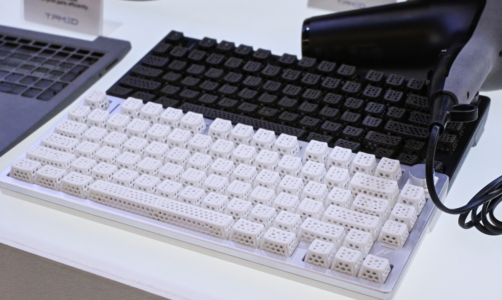 Protótipos de eletrônicos de consumo, como teclas com estrutura em treliça e carcaças de laptops, produzidos com a tecnologia TPM3D SLS.