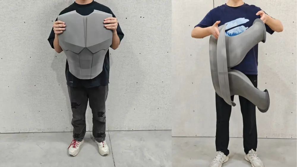 Large PEEK components printed on the TPM3D X1100HT, including robot chest armor and an air intake manifold